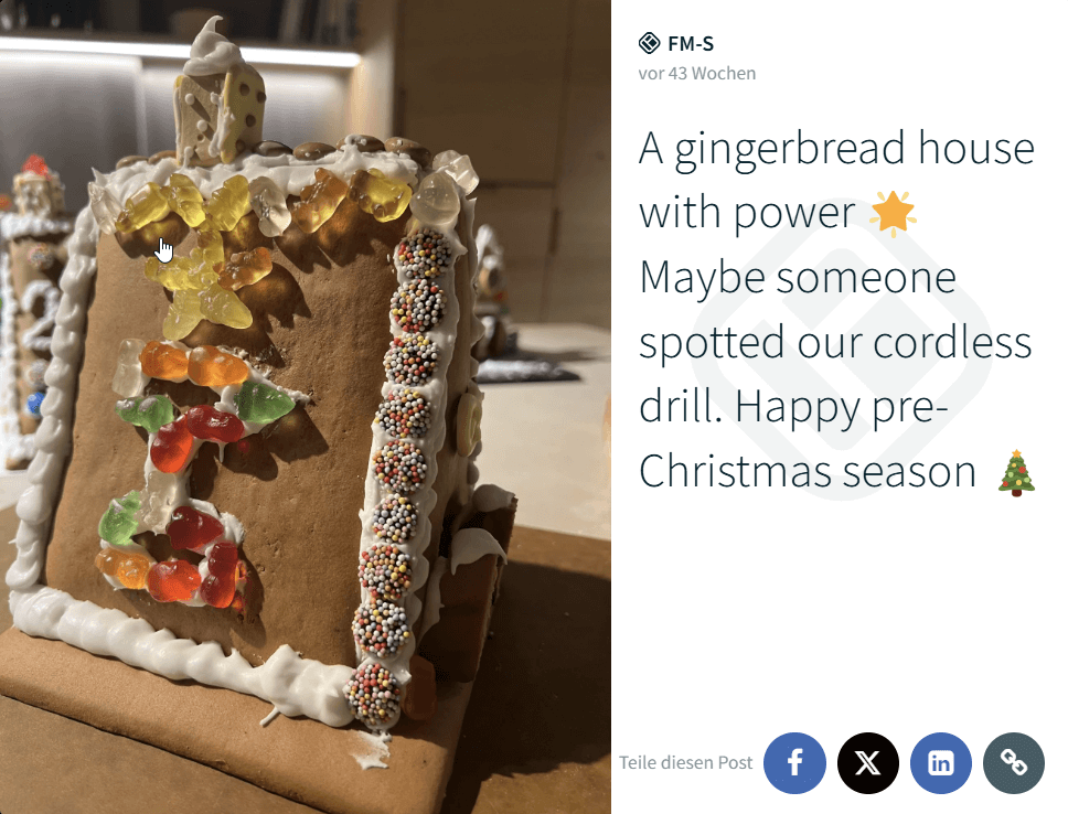 Close-up of a decorated gingerbread house made with gummy bears and icing, shared on a social wall post celebrating the pre-Christmas season.