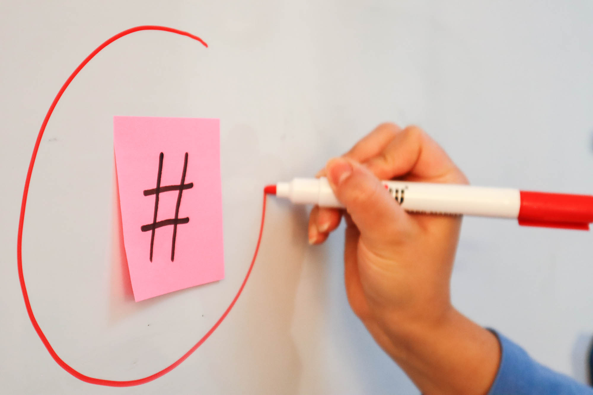 a person circling a hashtag with a red marker (social listening tools)