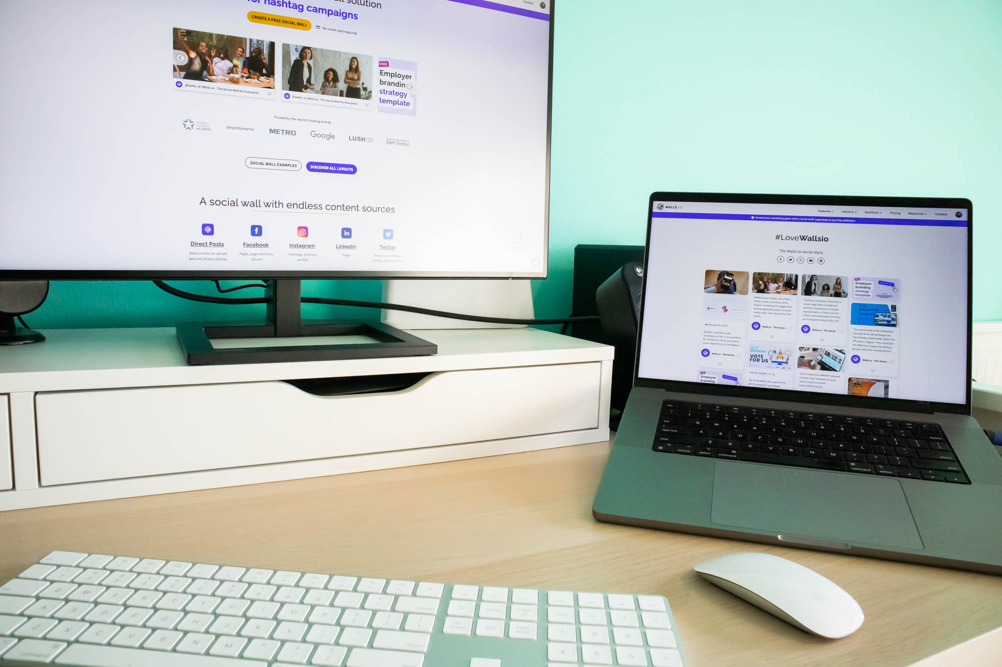 A desktop and a laptop displaying walls.io as a social listening tool through hashtag tracking.